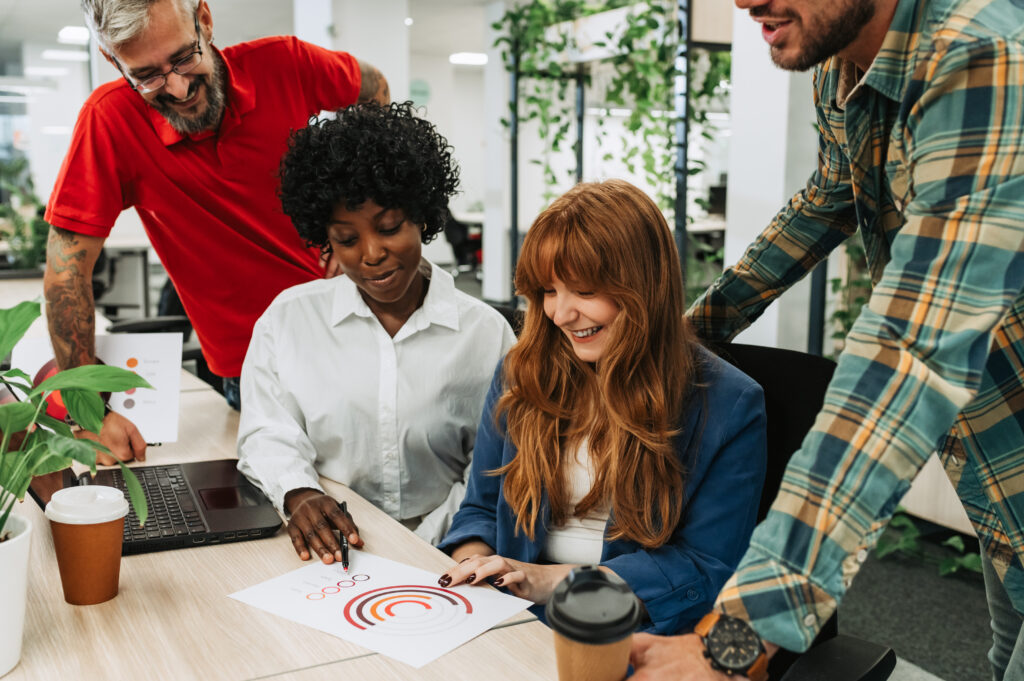 A diverse colleagues looking at the chart at modern office.